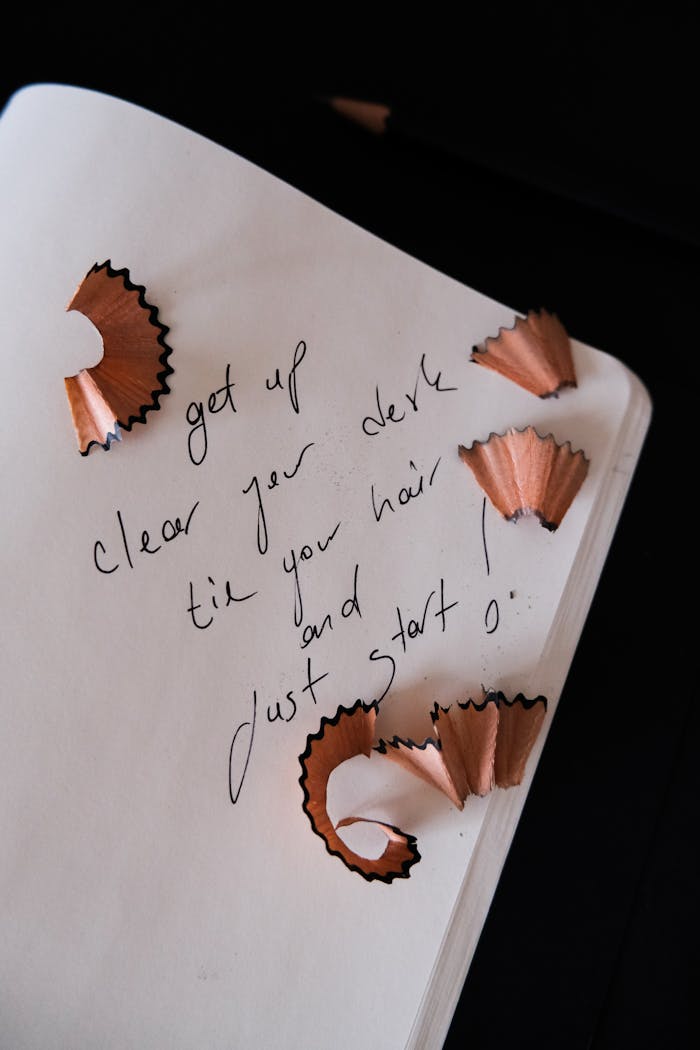 Home Handwritten message with pencil shavings on open notebook, inspiring start and motivation.