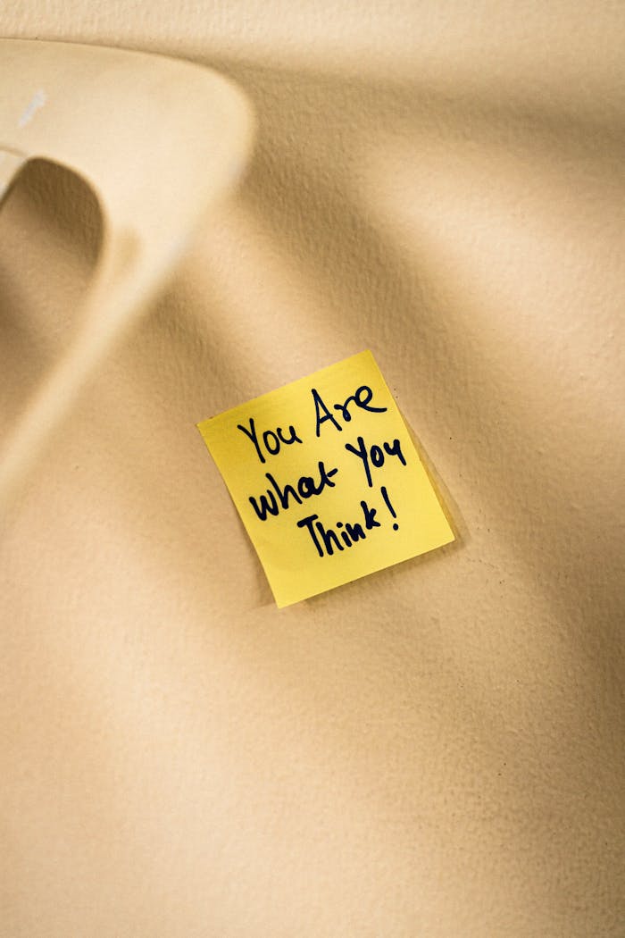 Home Yellow sticky note with motivational message on beige surface.